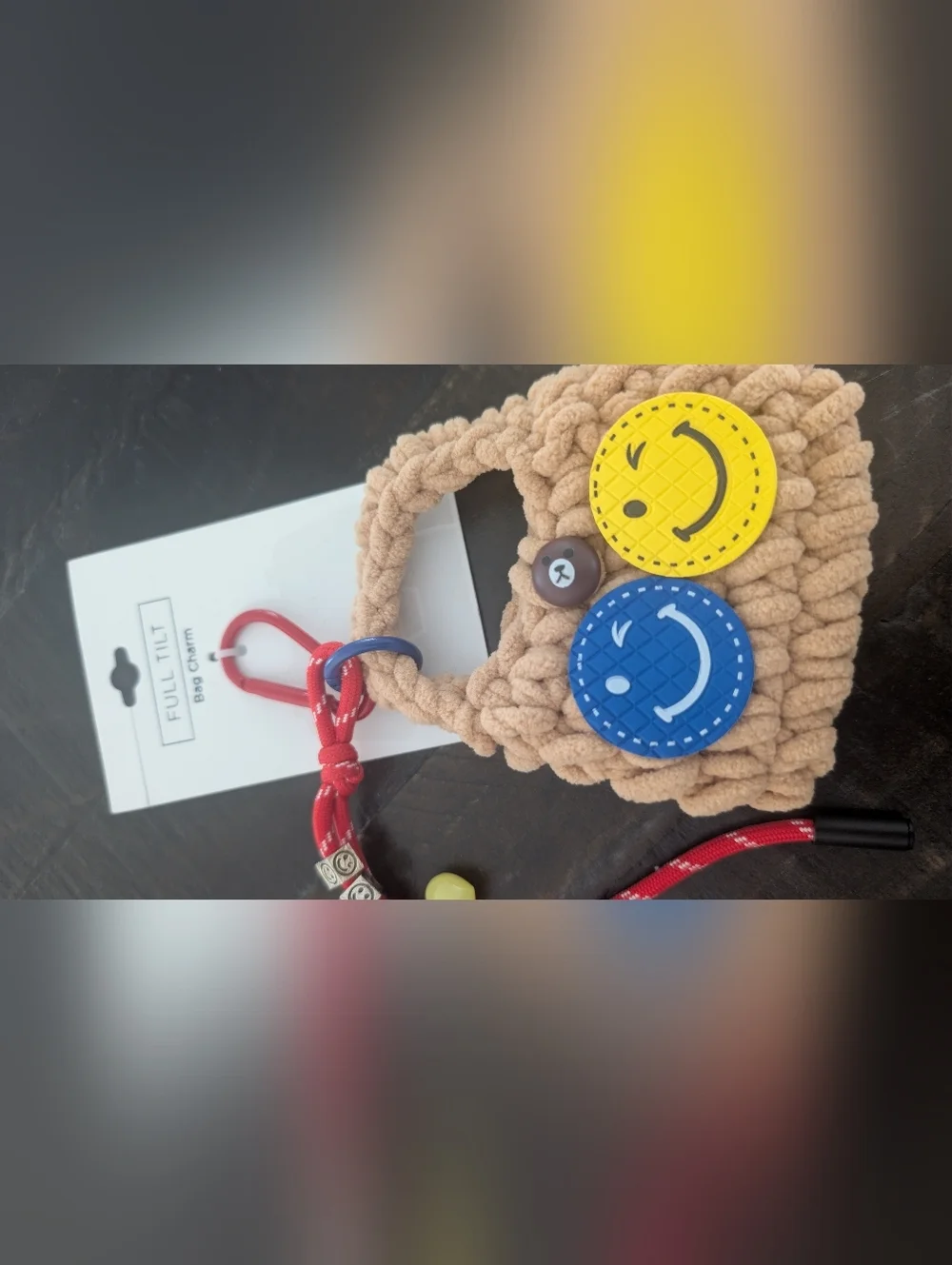 Full Tilt Beige Crochet Kids Bag Charm with Blue & Yellow Smiley Faces